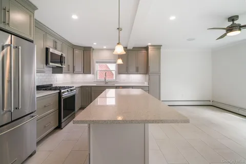 a kitchen with stainless steel appliances a refrigerator and a stove top oven