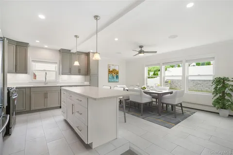 a large kitchen with kitchen island a sink a stove a dining table and chairs
