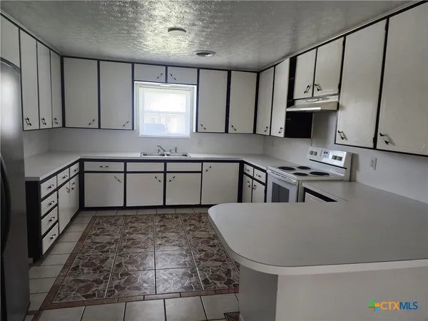 a kitchen with stainless steel appliances granite countertop a sink stove and cabinets