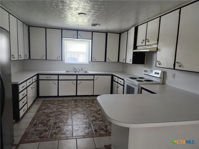 a kitchen with stainless steel appliances granite countertop a sink stove and cabinets
