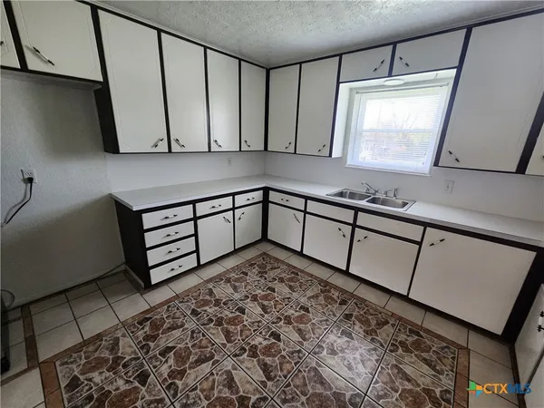 a view of a bathroom with a sink a mirror and a window