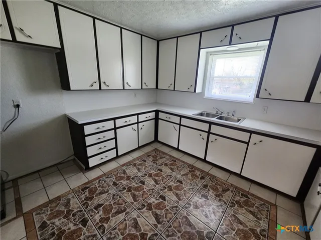 a view of a bathroom with a sink a mirror and a window