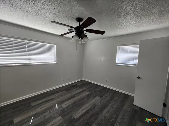 a view of room with hardwood floor and a ceiling fan