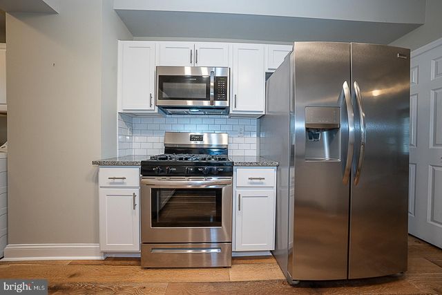 a kitchen with a stainless steel appliances and wooden floor