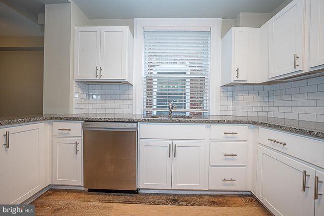 a kitchen with granite countertop white cabinets and white appliances