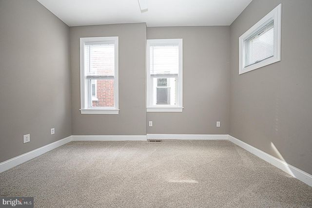 a bathroom with a granite countertop sink and a window