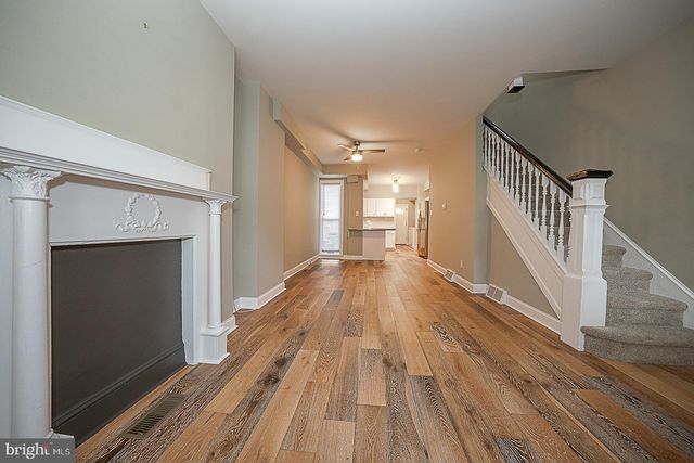 a view of a hallway with wooden floor and staircase