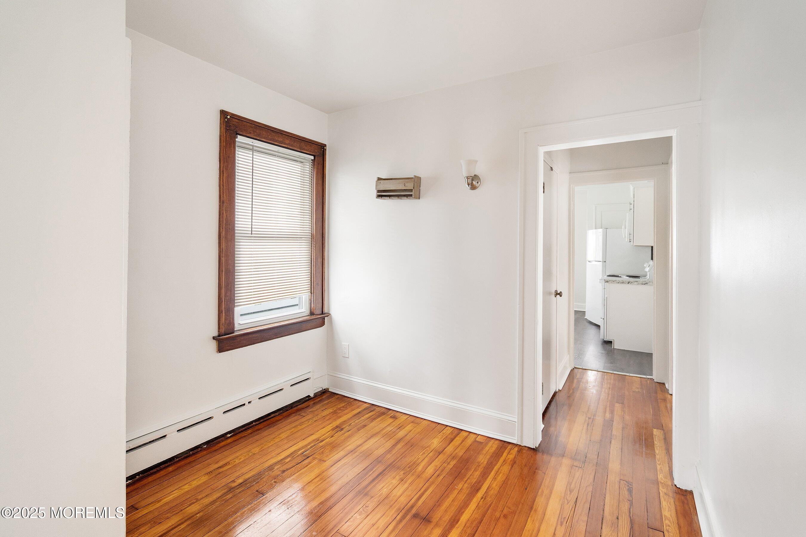 56 Ford Avenue, Unit 2 Fords, NJ 08863 - Photo 11 of 22 a view of an empty room with wooden floor and a window