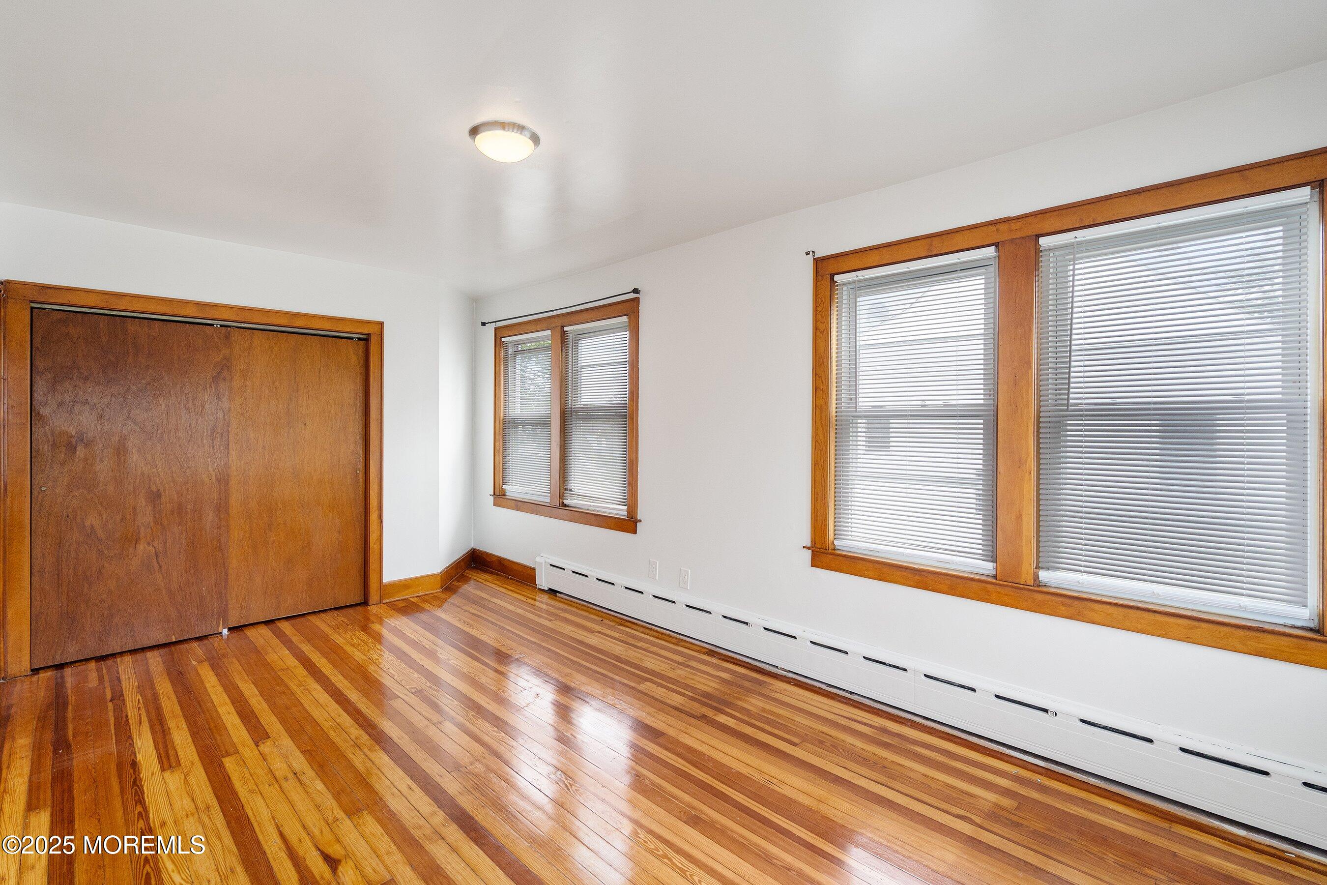 56 Ford Avenue, Unit 2 Fords, NJ 08863 - Photo 13 of 22 a view of an empty room with wooden floor and a window