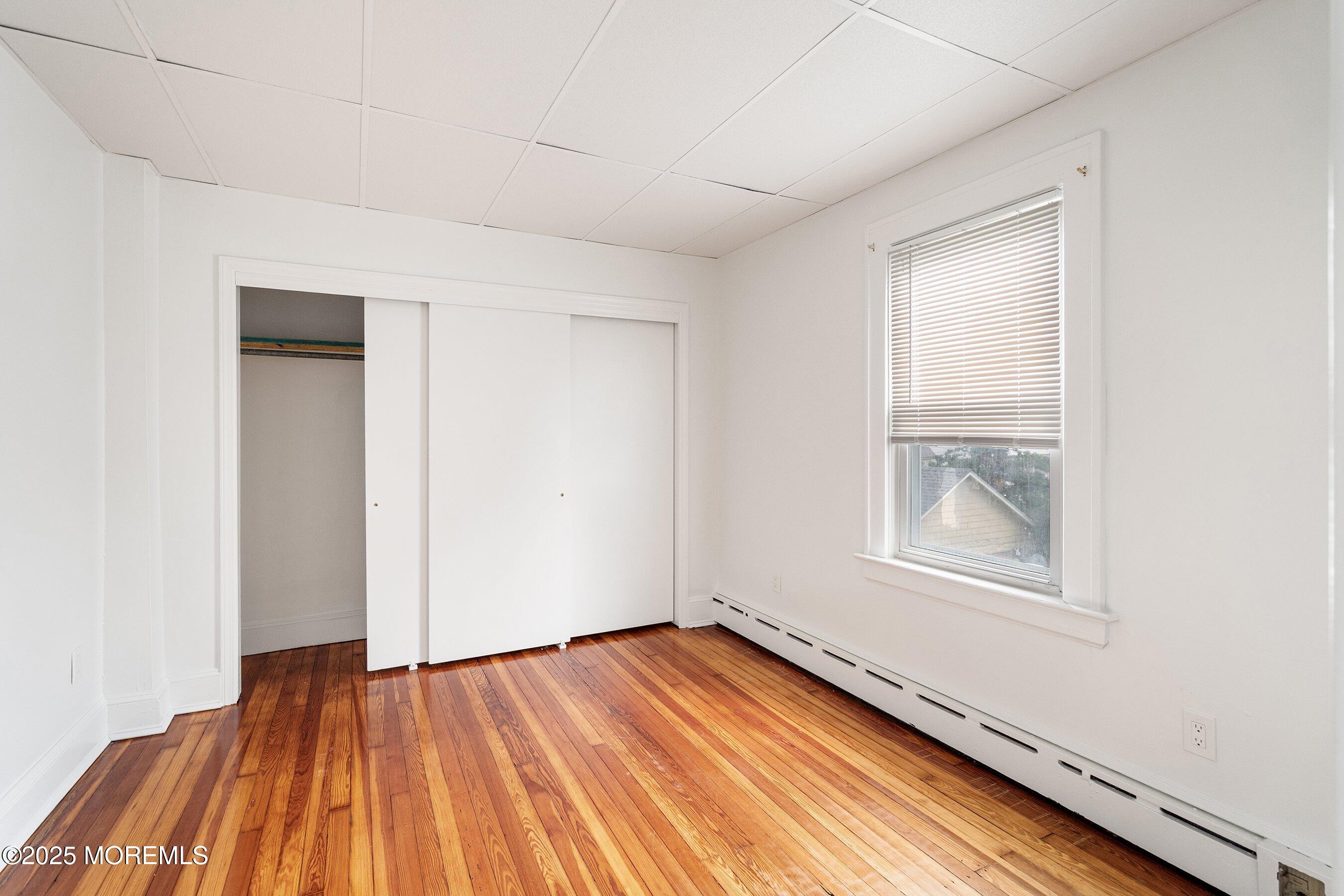 56 Ford Avenue, Unit 2 Fords, NJ 08863 - Photo 14 of 22 an empty room with wooden floor and windows
