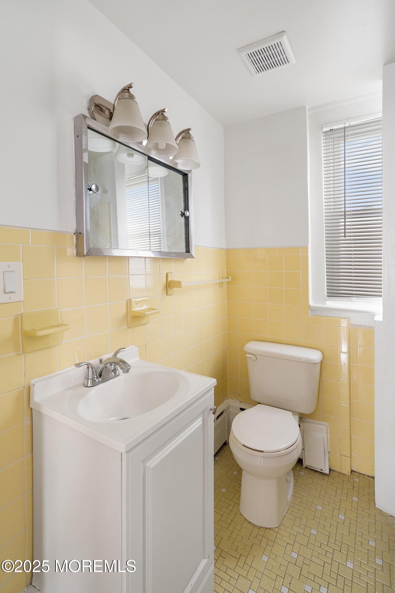 56 Ford Avenue, Unit 2 Fords, NJ 08863 - Photo 16 of 22 a bathroom with a sink a toilet and a mirror