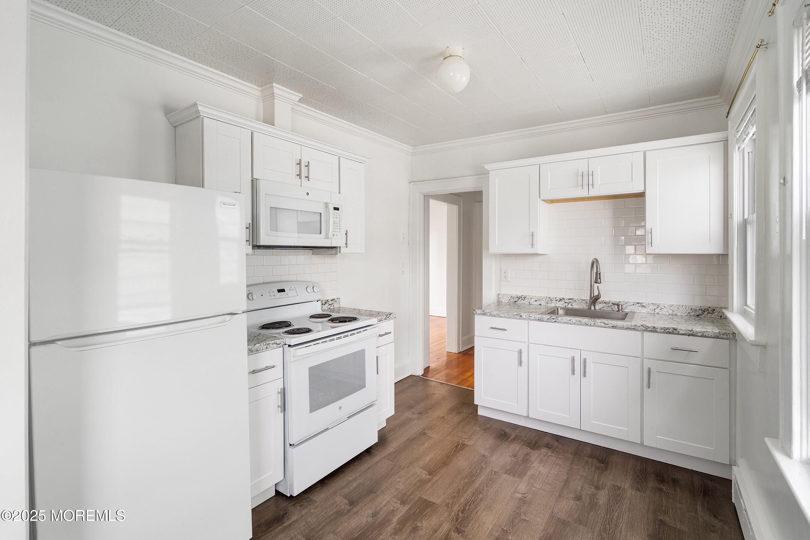 56 Ford Avenue, Unit 2 Fords, NJ 08863 - Photo 4 of 22 a kitchen with granite countertop white cabinets and white appliances