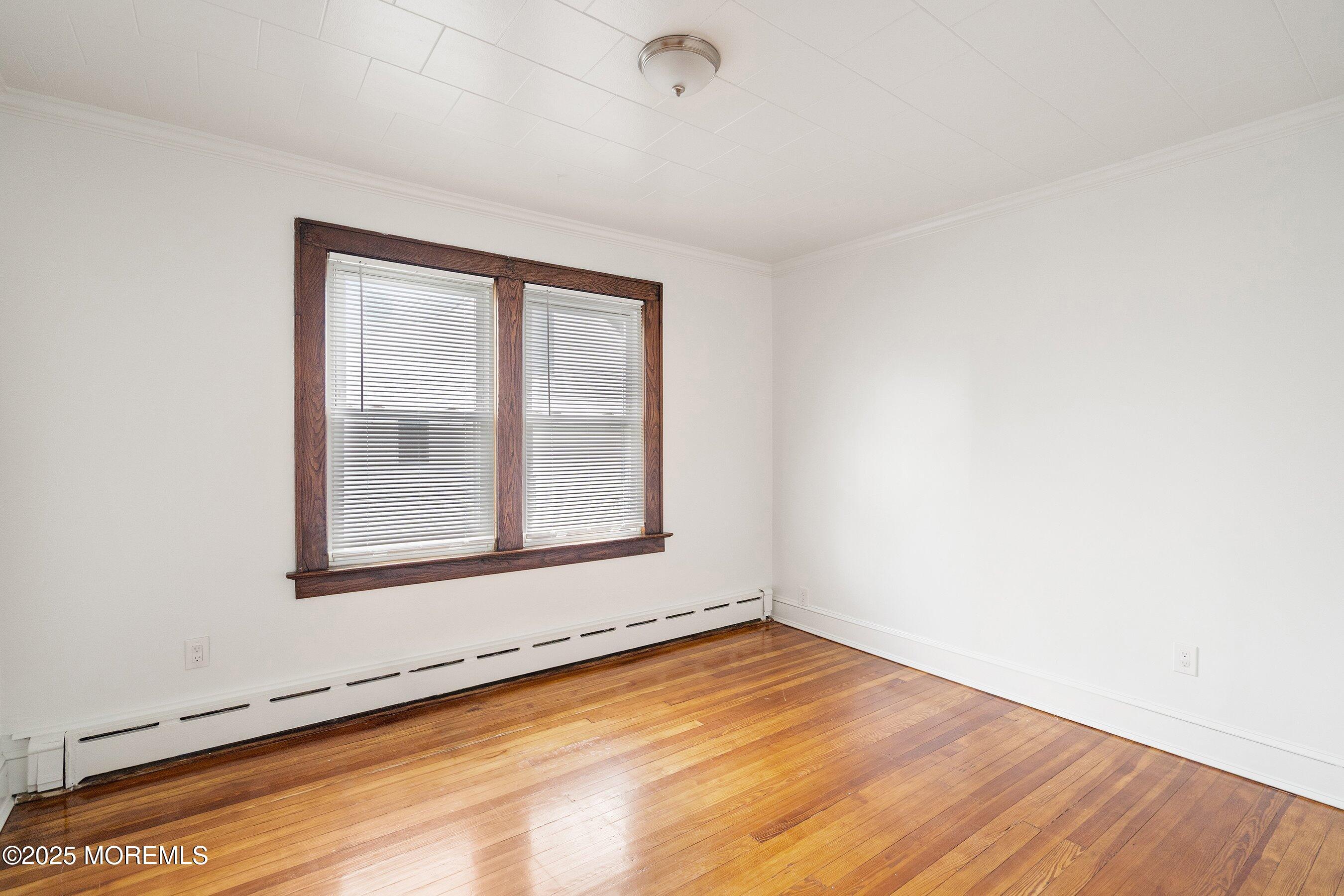 56 Ford Avenue, Unit 2 Fords, NJ 08863 - Photo 9 of 22 an empty room with wooden floor and windows