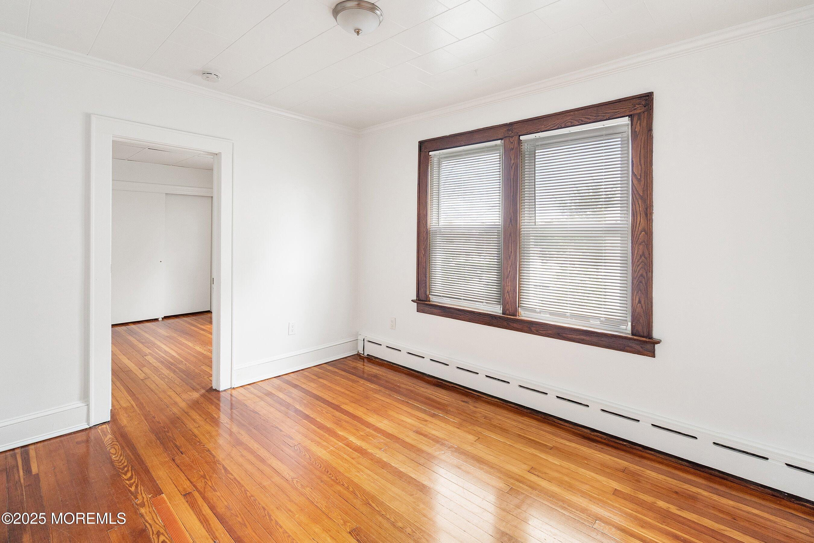 56 Ford Avenue, Unit 2 Fords, NJ 08863 - Photo 10 of 22 a view of an empty room with wooden floor and a window