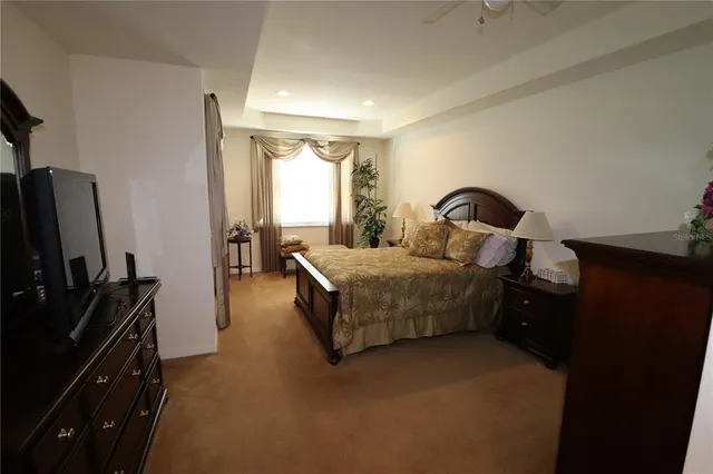 a bedroom with a bed and a flat tv screen on a dresser