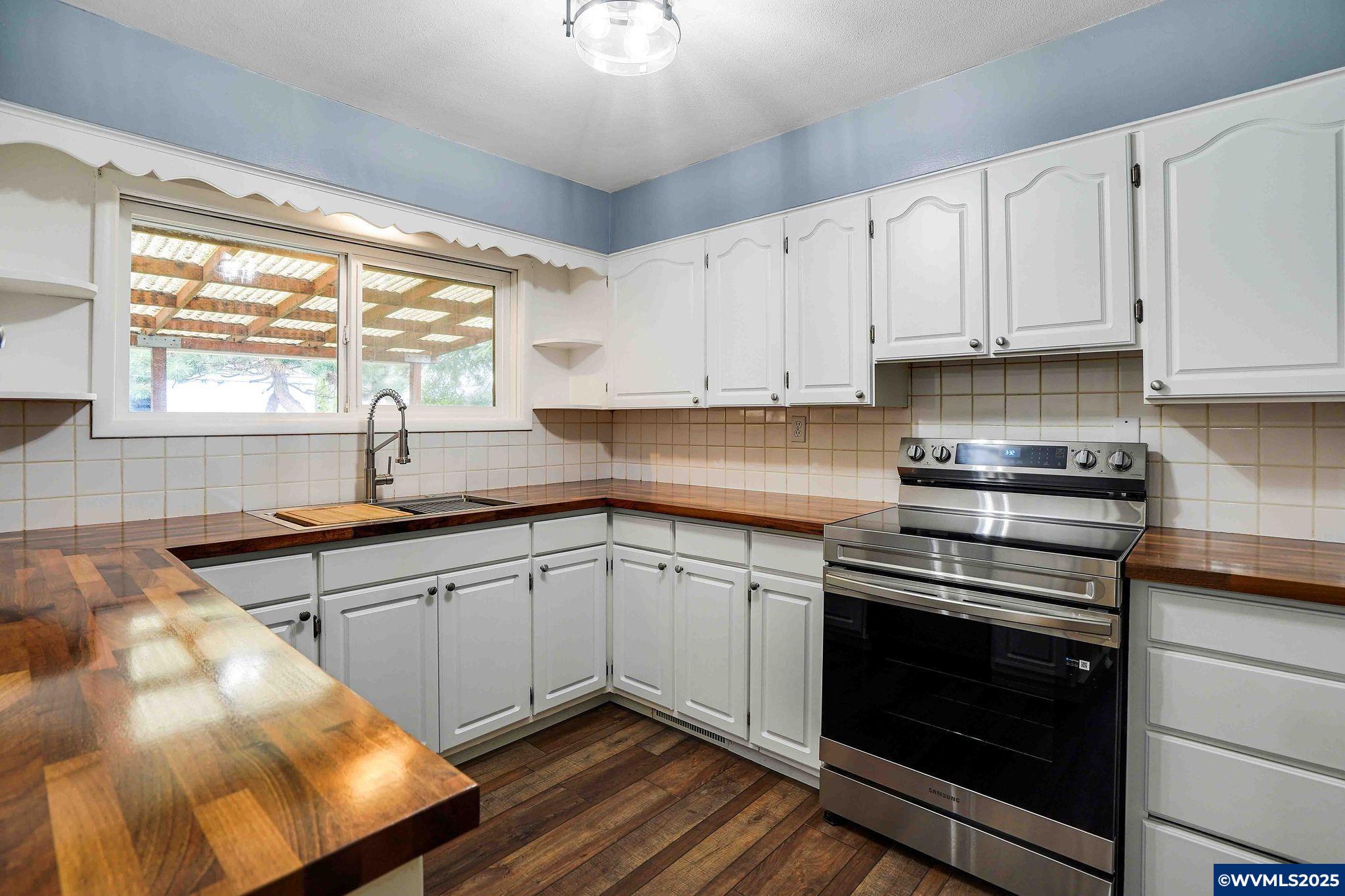 4843 Hazelgreen Road Northeast Salem, OR 97305 - Photo 6 of 48 a kitchen with stainless steel appliances granite countertop a stove a sink and white cabinets