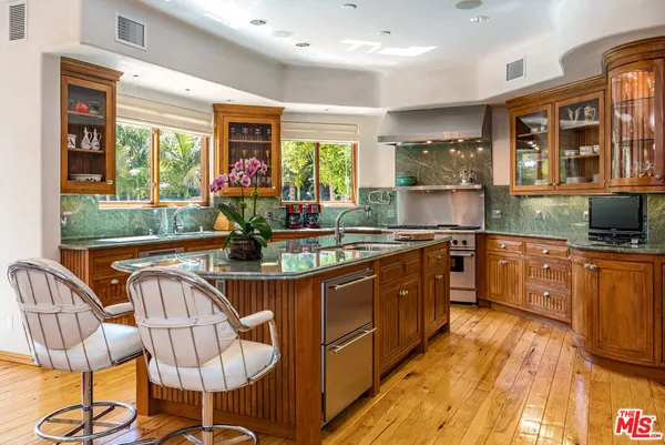 a kitchen with stainless steel appliances granite countertop a stove a sink and a refrigerator