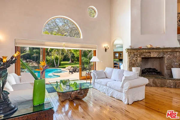 a living room with fireplace furniture and a large window