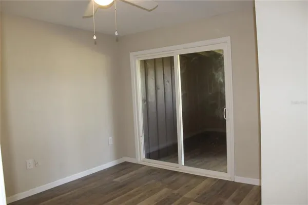 an empty room with wooden floor closet and chandelier