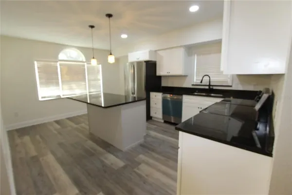 a kitchen with stainless steel appliances granite countertop a stove a sink and a refrigerator
