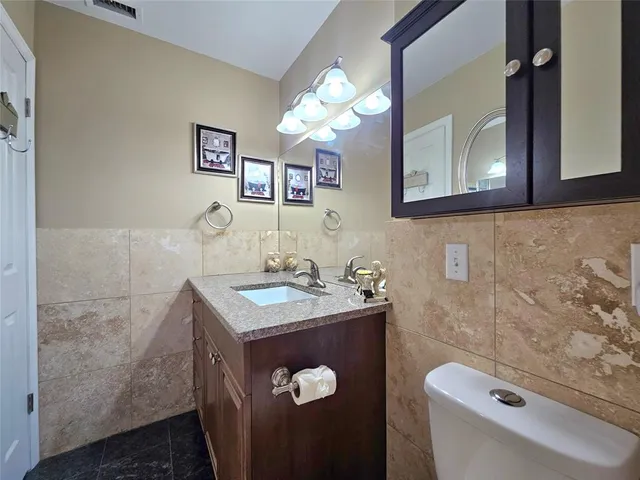 a bathroom with a sink a toilet and mirror