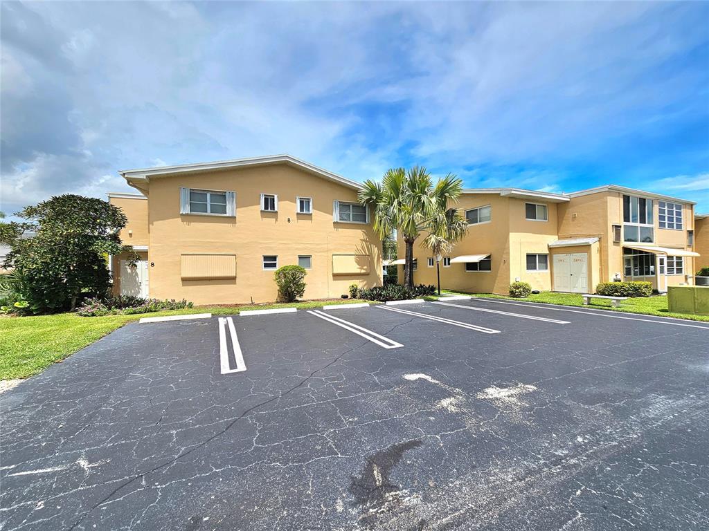 2141 Northeast 1st Court, Unit 201 Boynton Beach, FL 33435 - Photo 17 of 26 a front view of a house with a yard and garage