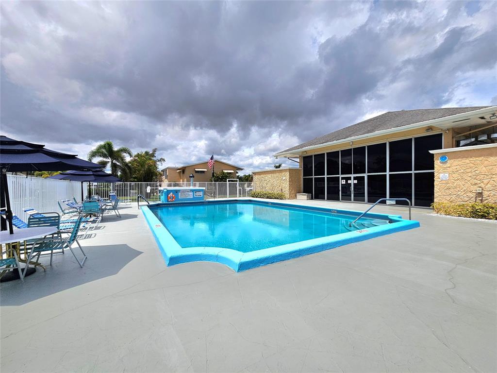 2141 Northeast 1st Court, Unit 201 Boynton Beach, FL 33435 - Photo 18 of 26 a view of a swimming pool with outdoor seating
