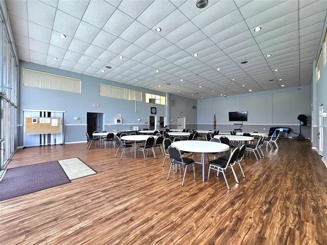 a view of a dining hall with lots of furniture and wooden floor
