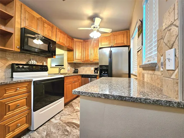 a kitchen with stainless steel appliances granite countertop a sink stove and refrigerator