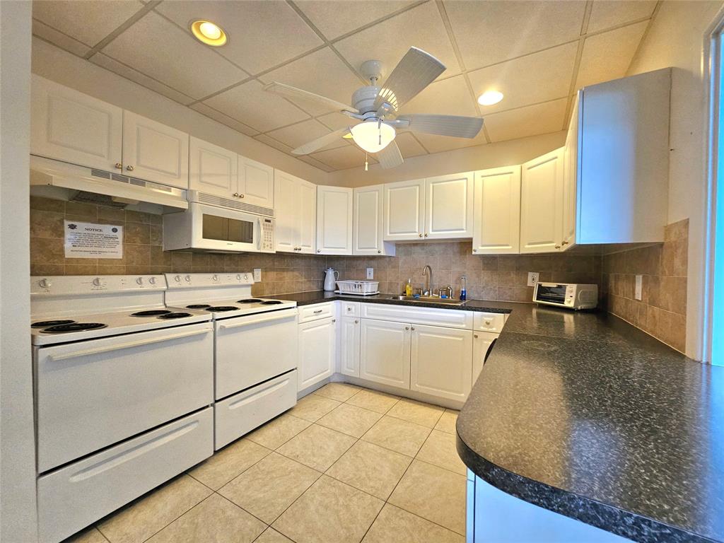 2141 Northeast 1st Court, Unit 201 Boynton Beach, FL 33435 - Photo 22 of 26 a kitchen with a sink cabinets and window