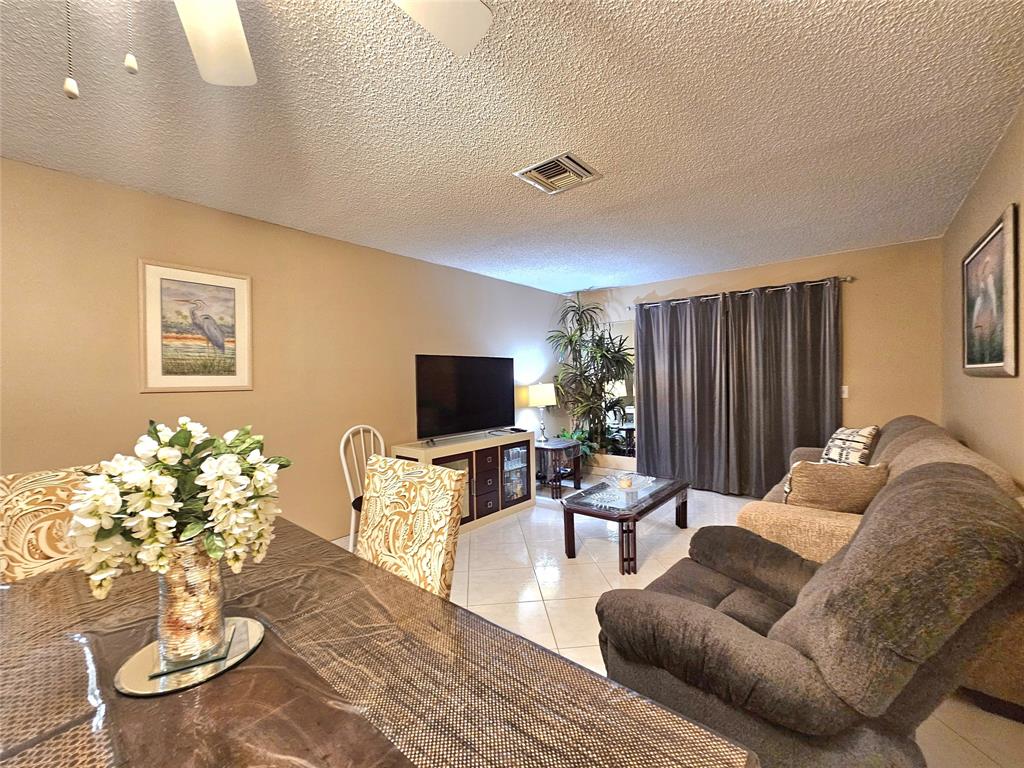 2141 Northeast 1st Court, Unit 201 Boynton Beach, FL 33435 - Photo 5 of 26 a living room with furniture and a flat screen tv