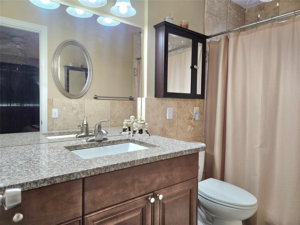 2141 Northeast 1st Court, Unit 201 Boynton Beach, FL 33435 - Photo 10 of 26 a bathroom with a granite countertop toilet a sink and a mirror