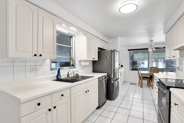 a kitchen with white cabinets and stainless steel appliances
