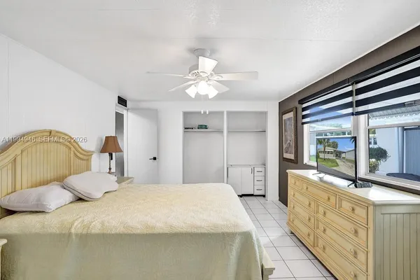 a bedroom with a bed and a large window with the outer view