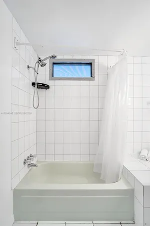 a bathroom with a shower and a bath tub