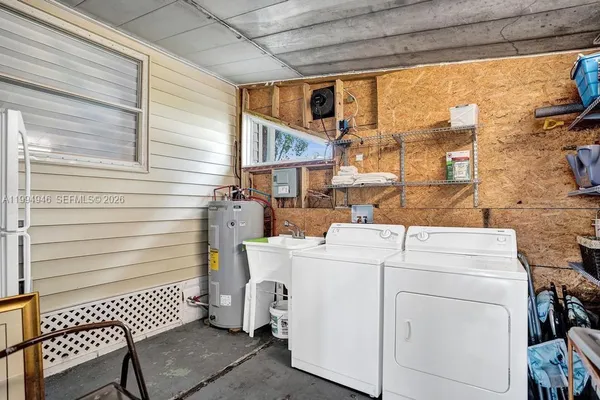 a view of washer and dryer with bathroom in the background