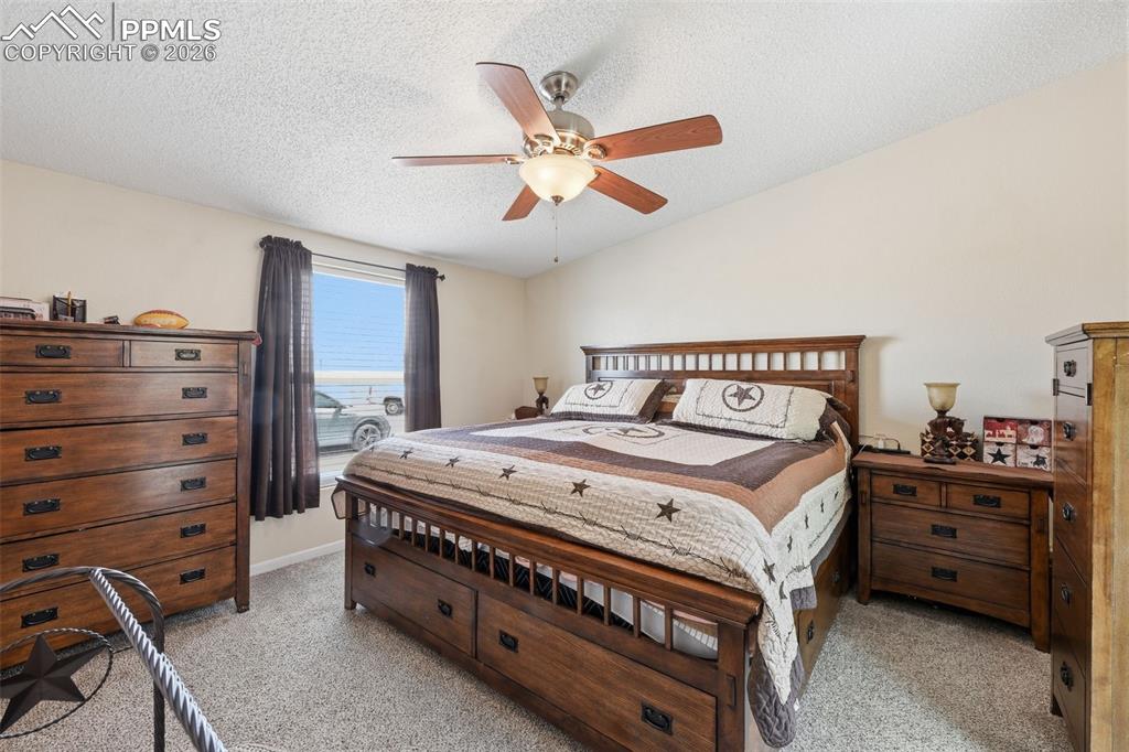 20985 McDaniels Road Calhan, CO 80808 - Photo 28 of 41 a bedroom with a bed and a chandelier