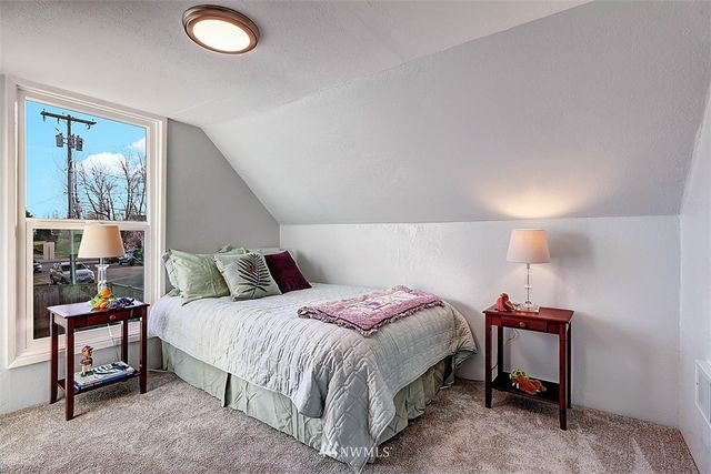 a bedroom with a bed and a lamp on dresser