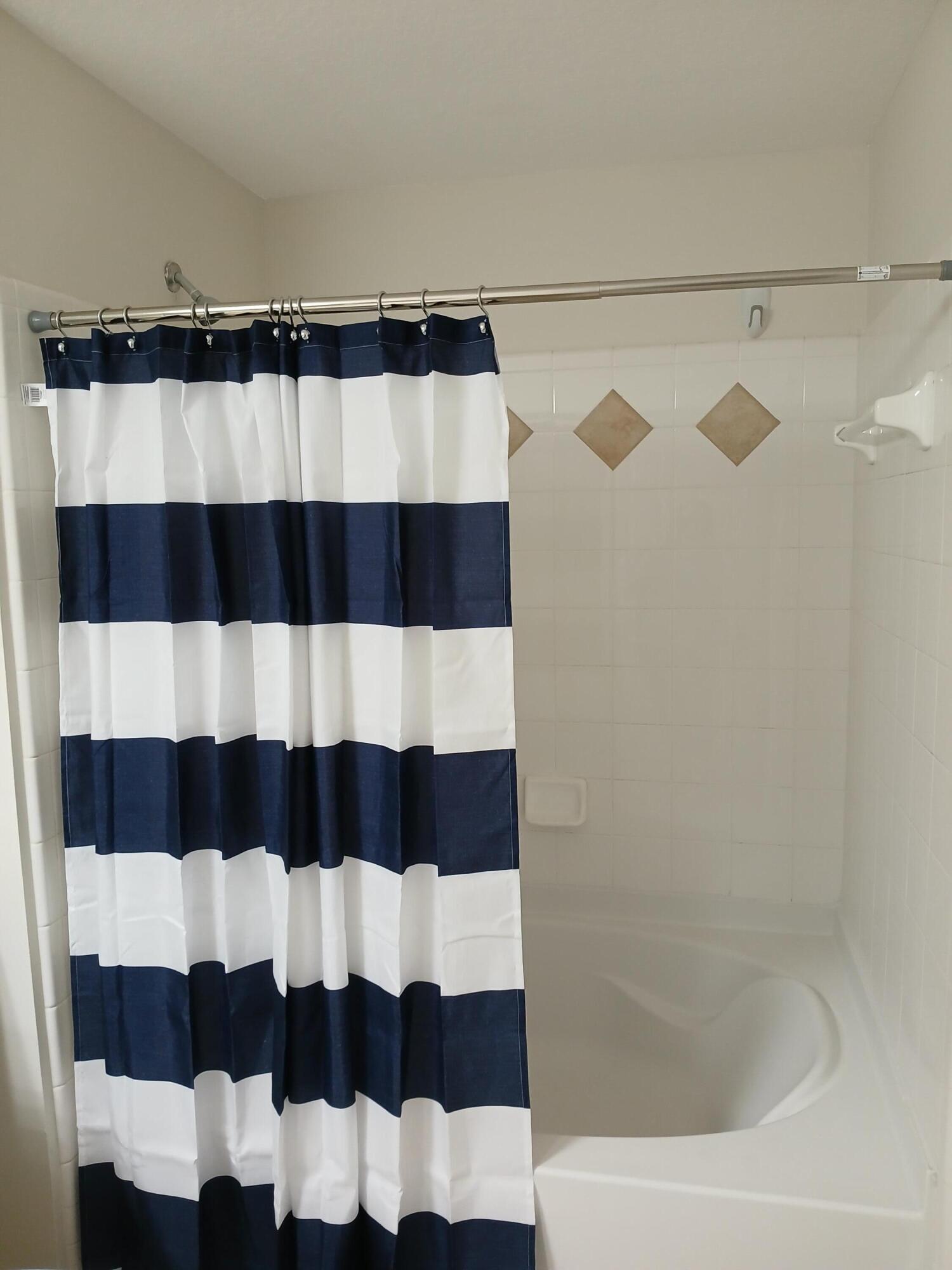 9857 Baywinds Boulevard, Unit 9212 Royal Palm Beach, FL 33411 - Photo 22 of 23 a bathroom with a bathtub and a shower