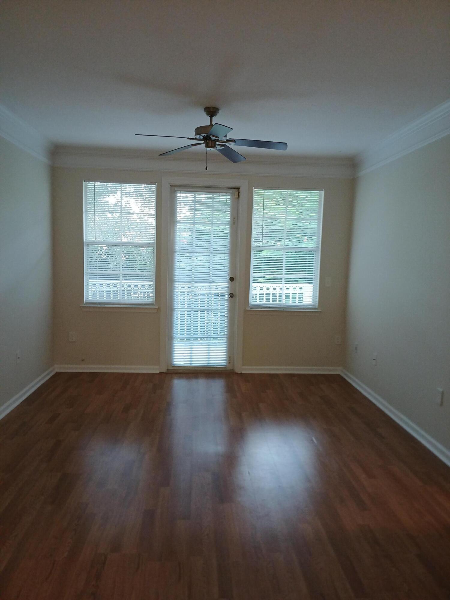 9857 Baywinds Boulevard, Unit 9212 Royal Palm Beach, FL 33411 - Photo 3 of 23 an empty room with wooden floor and windows
