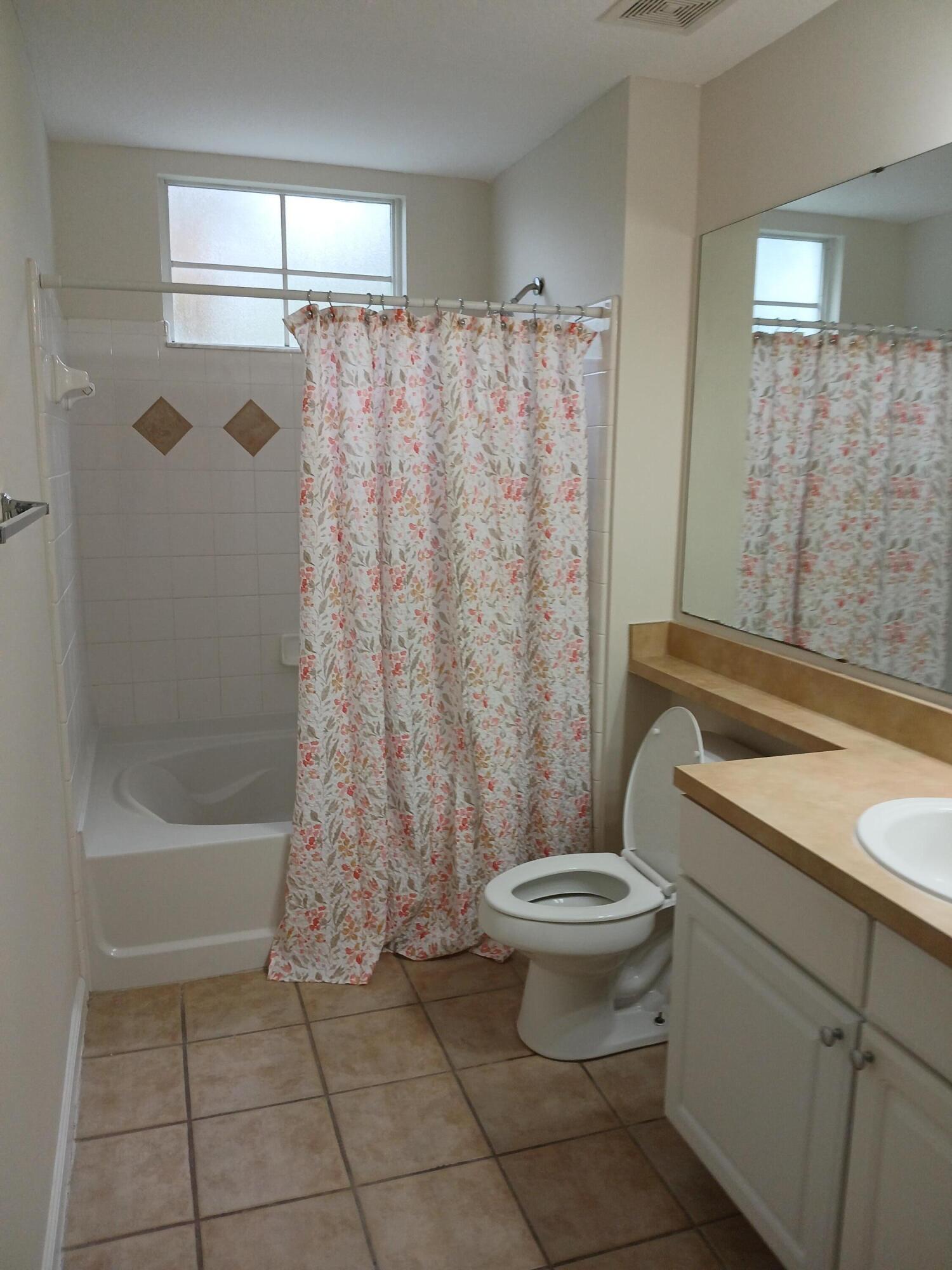 9857 Baywinds Boulevard, Unit 9212 Royal Palm Beach, FL 33411 - Photo 4 of 23 a bathroom with a toilet and a shower