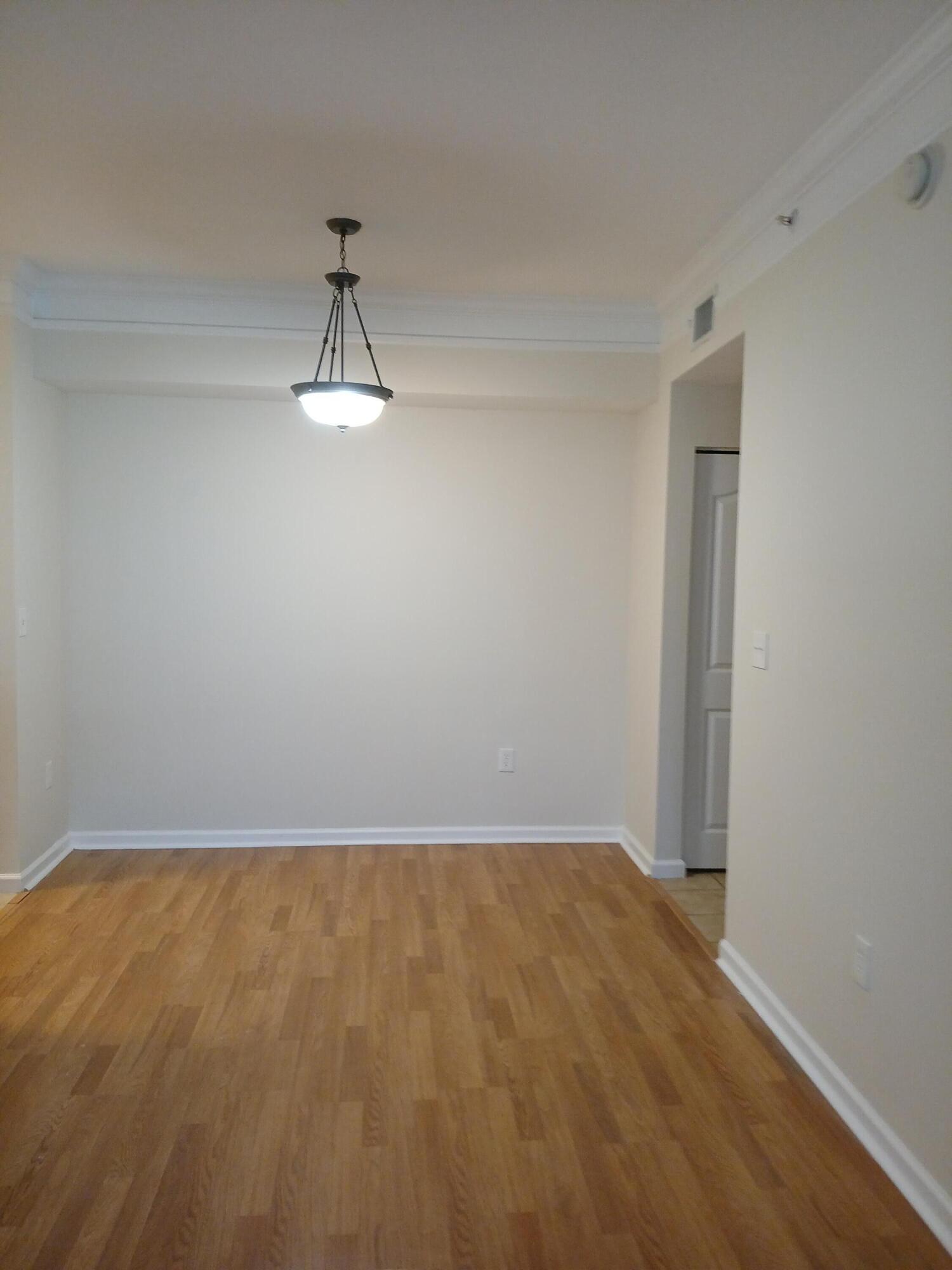 9857 Baywinds Boulevard, Unit 9212 Royal Palm Beach, FL 33411 - Photo 7 of 23 a view of a room with wooden floor and white walls