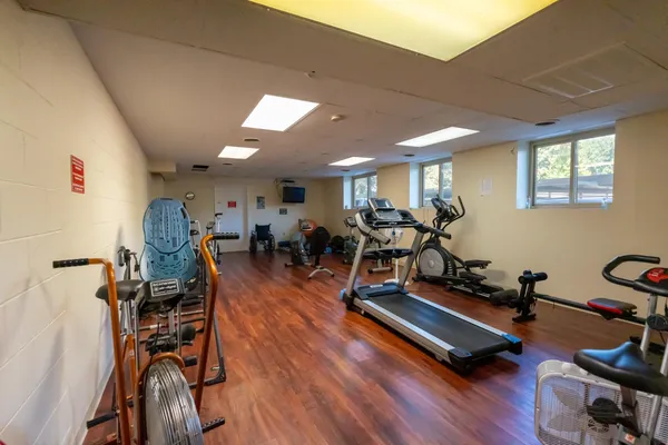 a room with gym equipment and wooden floor