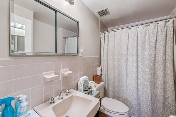a bathroom with a sink a toilet and a mirror