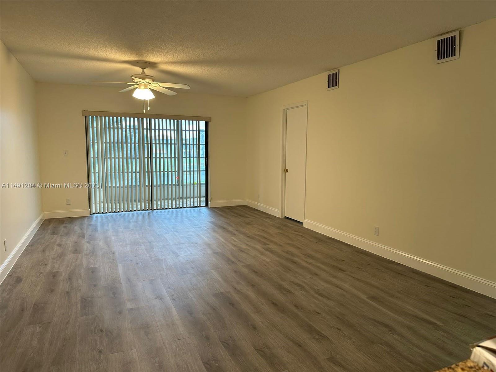 Arrowhead Condominium Davie, FL 33324 - Photo 13 of 23 a view of an empty room with wooden floor and a window