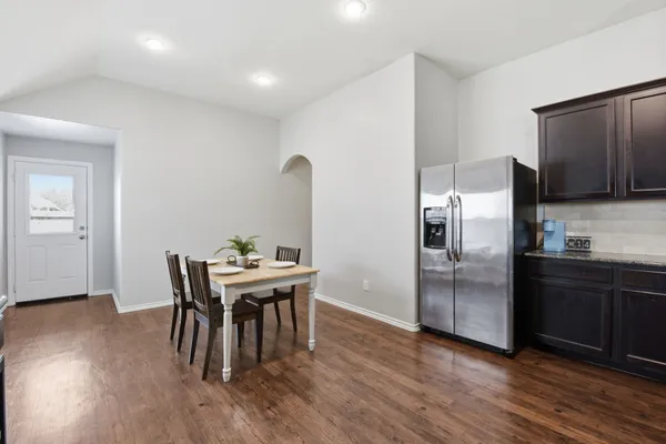 a kitchen with stainless steel appliances wooden floor dining table and chairs