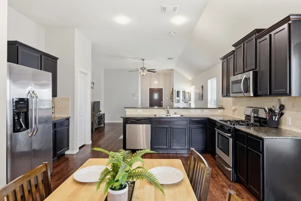 a kitchen with stainless steel appliances granite countertop a sink stove and refrigerator