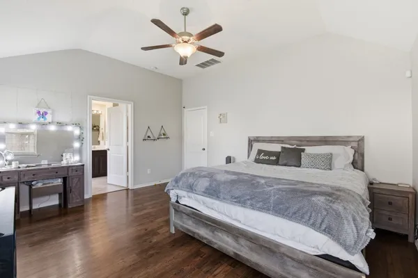 a spacious bedroom with a bed and a chandelier