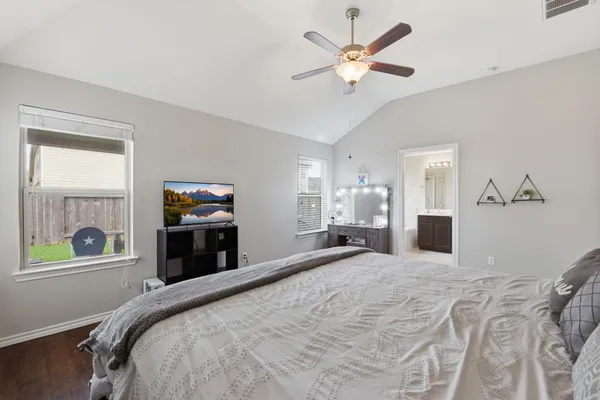 a bedroom with a bed and a tv on the dresser