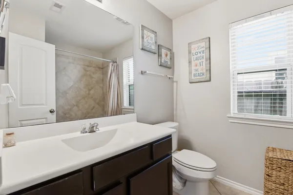 a bathroom with a sink toilet and a mirror